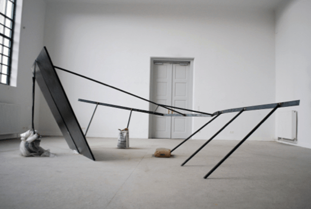 Thea Möller & Adria Zement,  Balance out of Wooden Plates and Metal Rods, 2012, doka-plates, steel, construction bucket, plastic foil, lashing strap, lacquer, 4 x 4 x 2 m